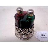 A coloured glass two-bottle scent decanter set in white metal stand, height 7.5 cm.