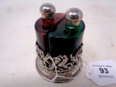 A coloured glass two-bottle scent decanter set in white metal stand, height 7.5 cm.