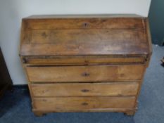 A 19th century oak fall fronted bureau fitted with four drawers