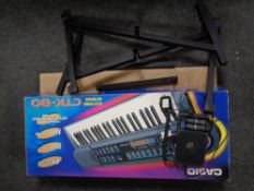 A Casio digital keyboard in box with stand together with a Panasonic radio