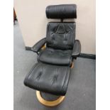 A Stressless Erkornes black leather adjustable swivel armchair with matching footstool