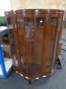 A mid century walnut shaped fronted display cabinet