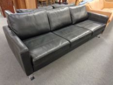 A Danish three seater in black leather on chrome legs