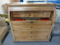 A 19th century oak barrel fronted bureau fitted with four drawers