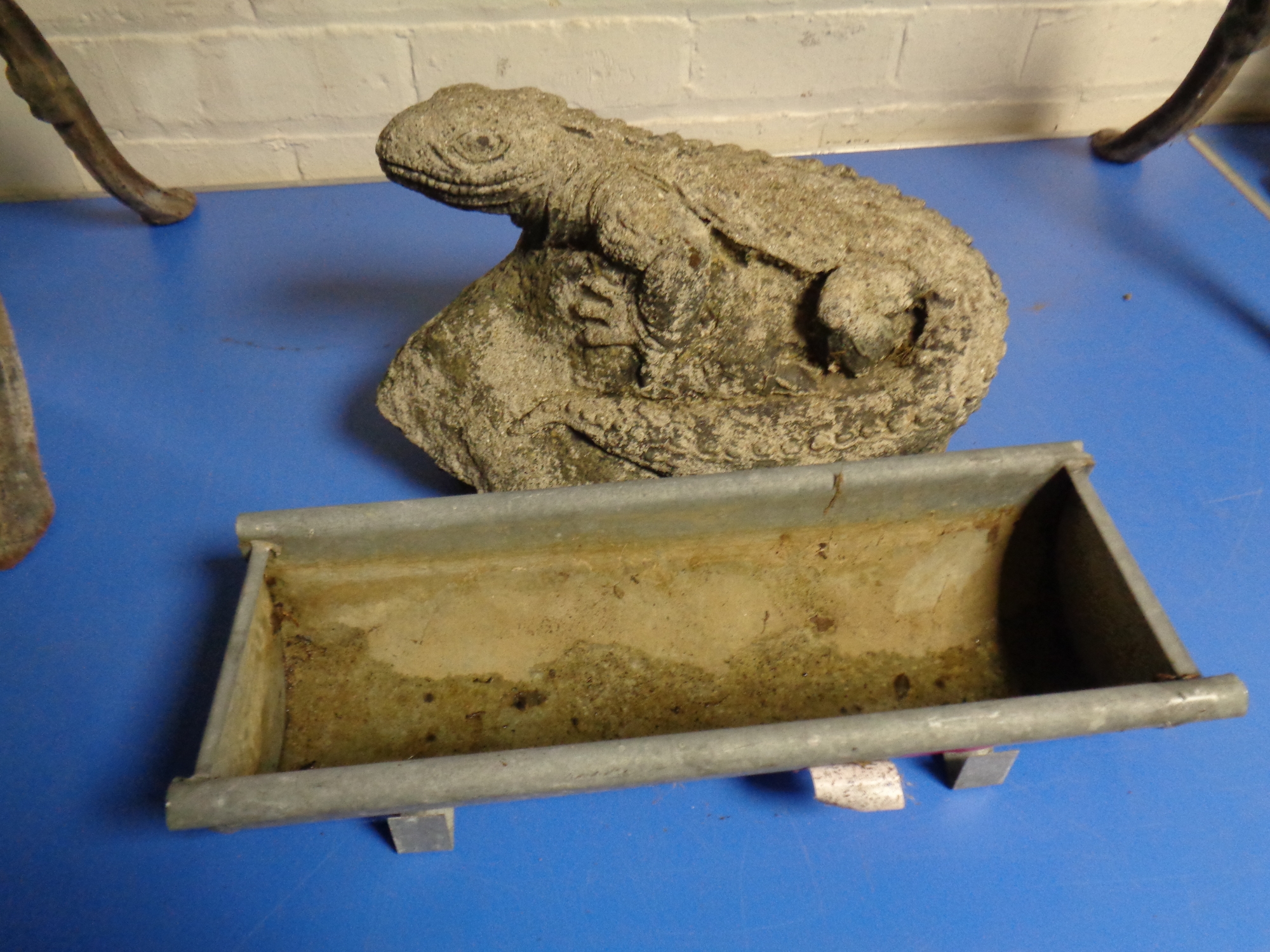 A concrete ornament - lizard on rock together with a small galvanized trough