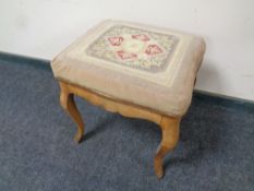 An antique walnut dressing table stool with tapestry seat