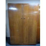 A mid century oak double door wardrobe together with a sunk centred dressing table with stool