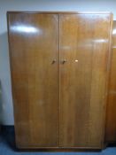 A mid century oak double door wardrobe together with a sunk centred dressing table with stool