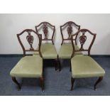 A set of four Edwardian mahogany dining chairs on cabriole legs upholstered in a green dralon