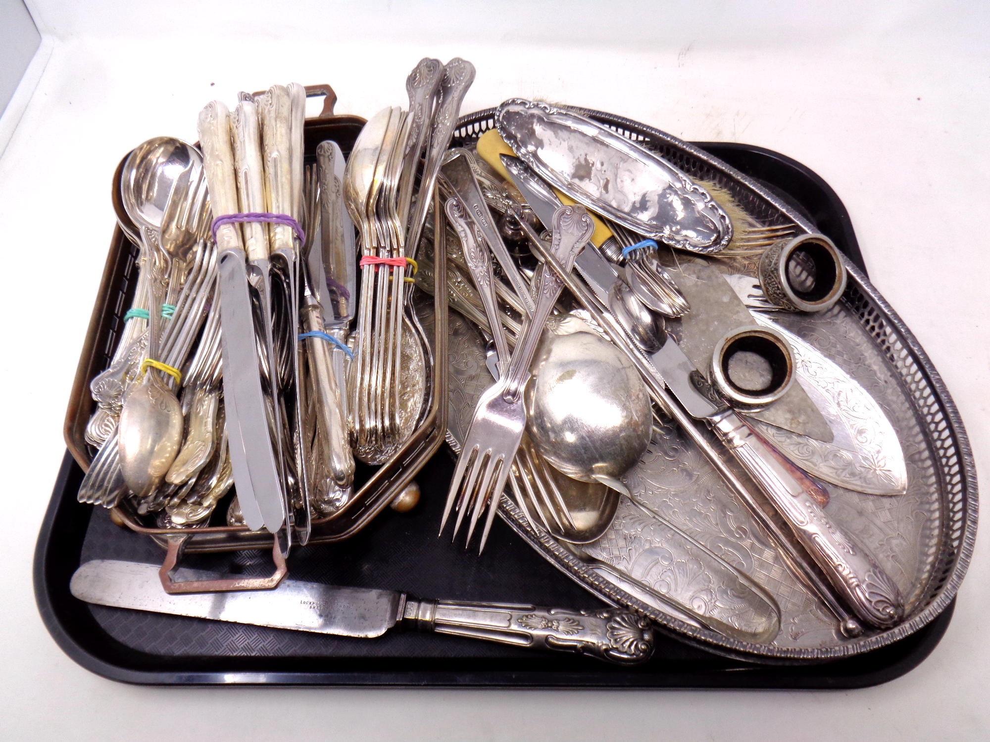 A tray containing two silver plated gallery trays together with a quantity of loose cutlery