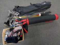 Two golf bags containing assorted Wilson golfing irons and drivers,