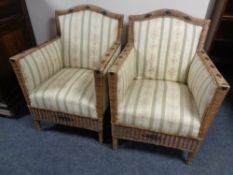 A pair of wicker armchairs upholstered in a striped fabric