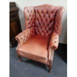 A Chesterfield buttoned leather wingback armchair