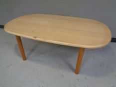 A oval coffee table in a pine finish