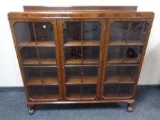 A Edwardian mahogany triple door glazed bookcase on claw and ball feet