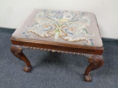 A 19th century style mahogany tapestry upholstered foot stool on claw and ball feet