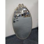 An oval gilt metal framed bevel edged mirror