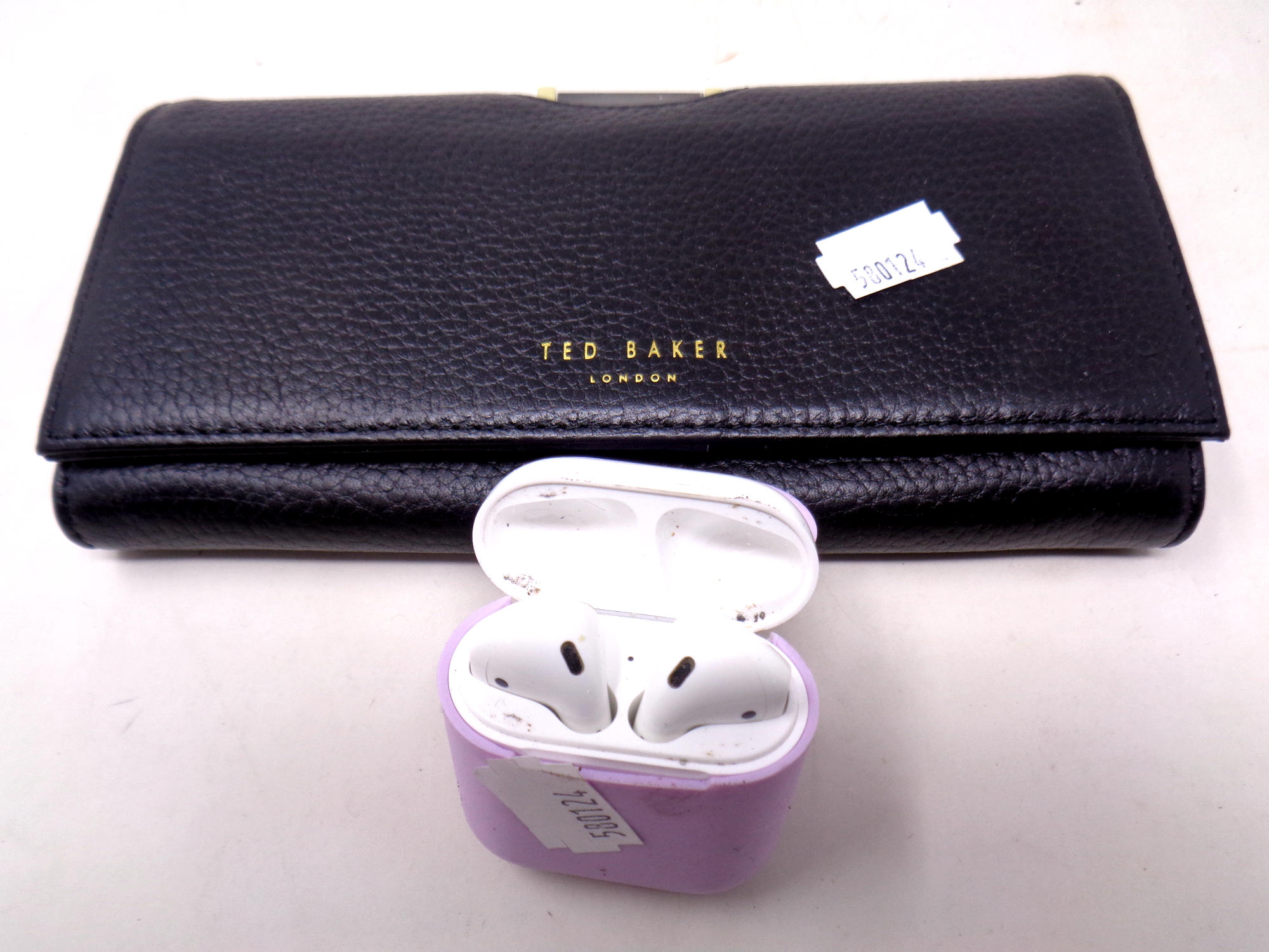 A Ted Baker black leather purse together with a pair of Apple air pods