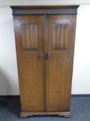 A Edwardian oak linen fold gentleman's wardrobe