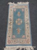 A Chinese embossed fringed rug on blue ground