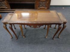 A nest of three mahogany tables on cabriole legs with plate glass tops