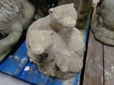 A concrete garden figure of 3 otters.