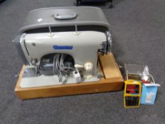 A 20th century Jones Sapphire electric sewing machine in case together with a tin containing