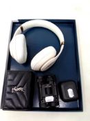 A pair of Beats headphones together with a Yves Saint Laurent black leather purse,