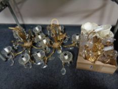 A pair of ornate brass five branch chandeliers with glass drops and cloth shades together with a