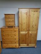 A pine double door wardrobe together with matching three door pine bedside chest and a similar pine