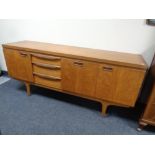 A mid 20th century teak sideboard fitted with three cupboards and three drawers by Greaves and