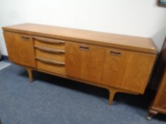 A mid 20th century teak sideboard fitted with three cupboards and three drawers by Greaves and