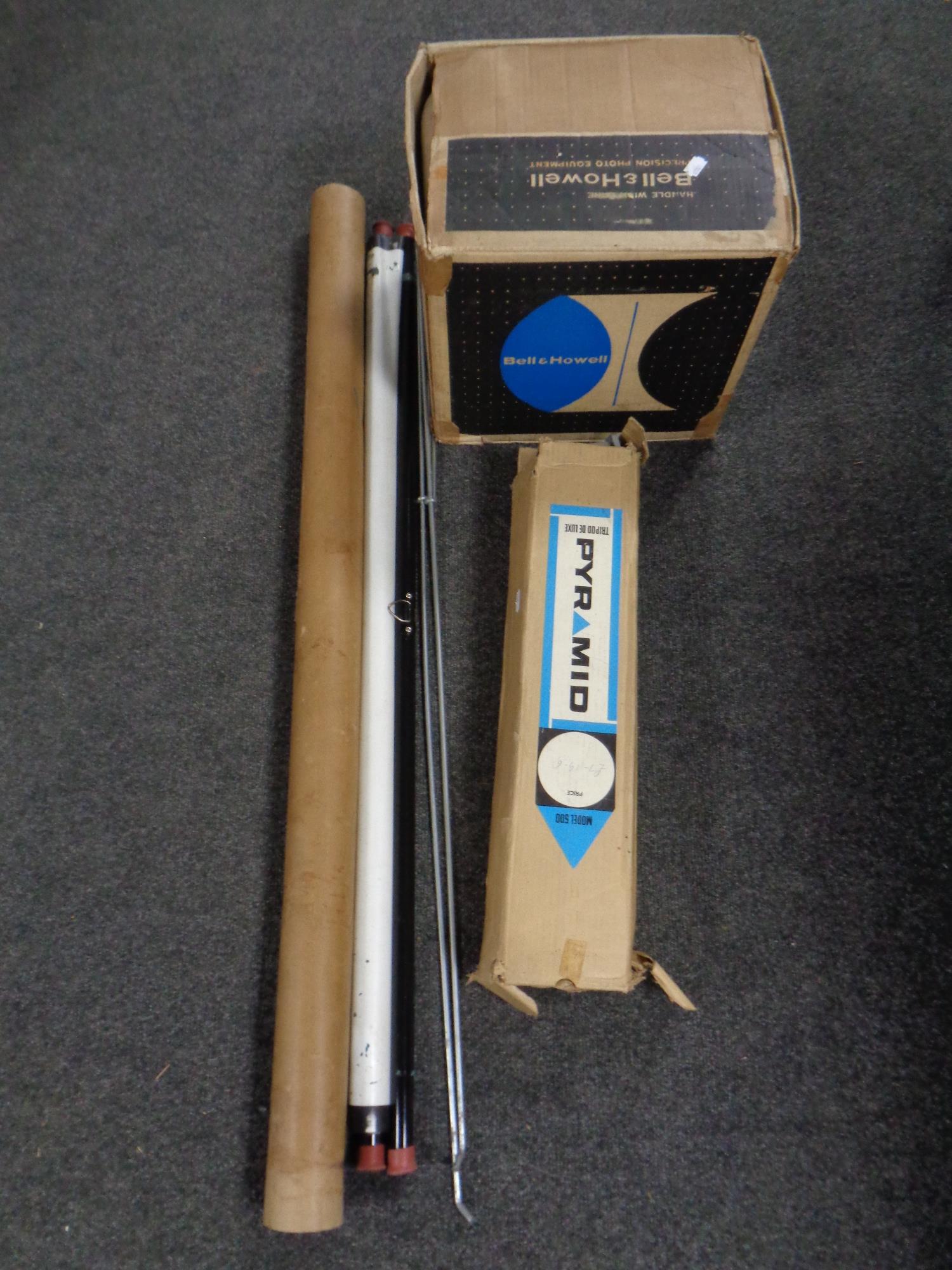 A Bell and Howell projector boxed together with a Pyramid camera tripod boxed and a projector