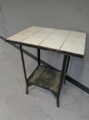 A 20th century cast iron tile topped two tier table
