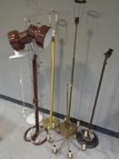 Five assorted continental floor lamps together with a brass eight way chandelier