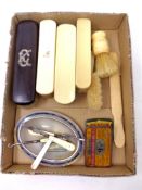 A box containing antique ivory dressing table brushes, vintage tins,