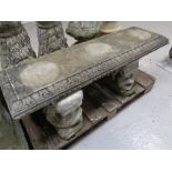 A concrete garden bench with Koi fish supports.