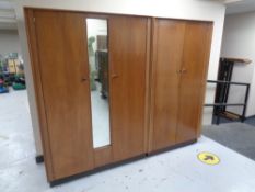 A 20th century teak effect double door wardrobe together with matching similar wardrobe with