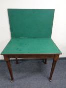 An Edwardian oak turn over top card table on club feet