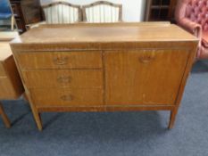 A mid 20th century mahogany cocktail sideboard fitted with three drawers