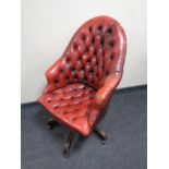 A Chesterfield button leather revolving armchair (red)