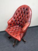 A Chesterfield button leather revolving armchair (red)