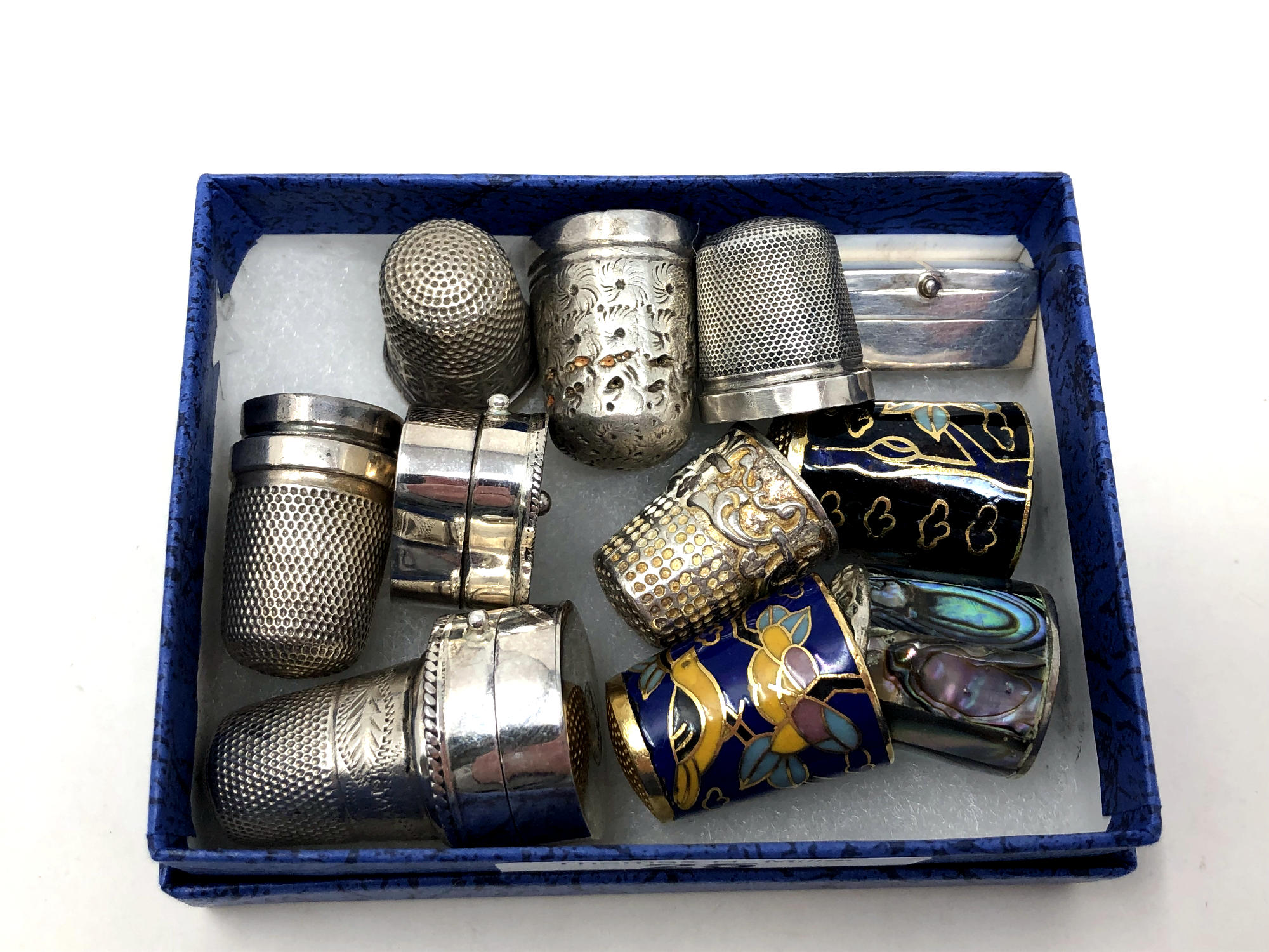 A group of thimbles including silver and cloisonne,