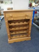 A pine wine rack fitted with a drawer