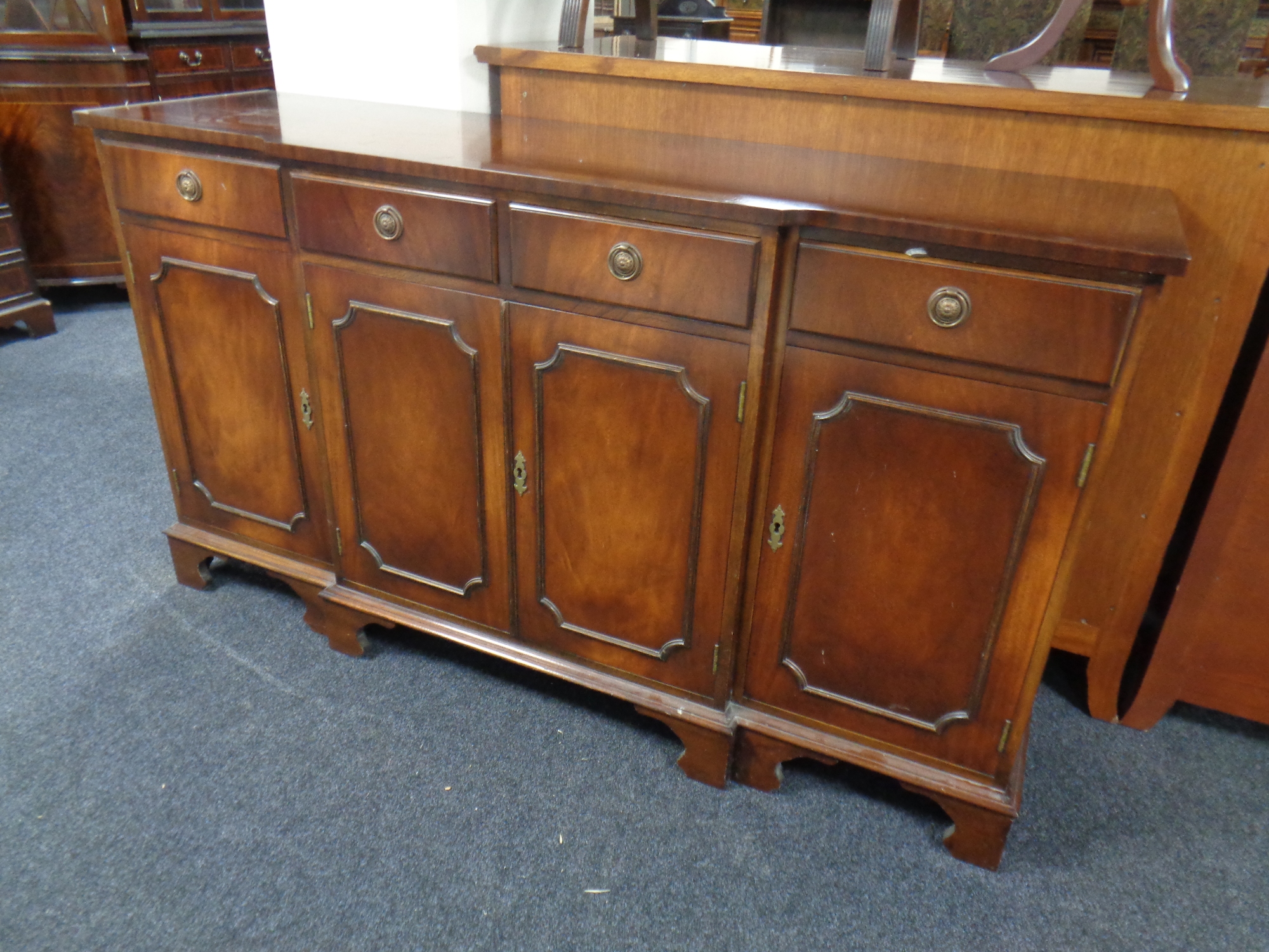 A Regency style mahogany four drawer break fronted sideboard