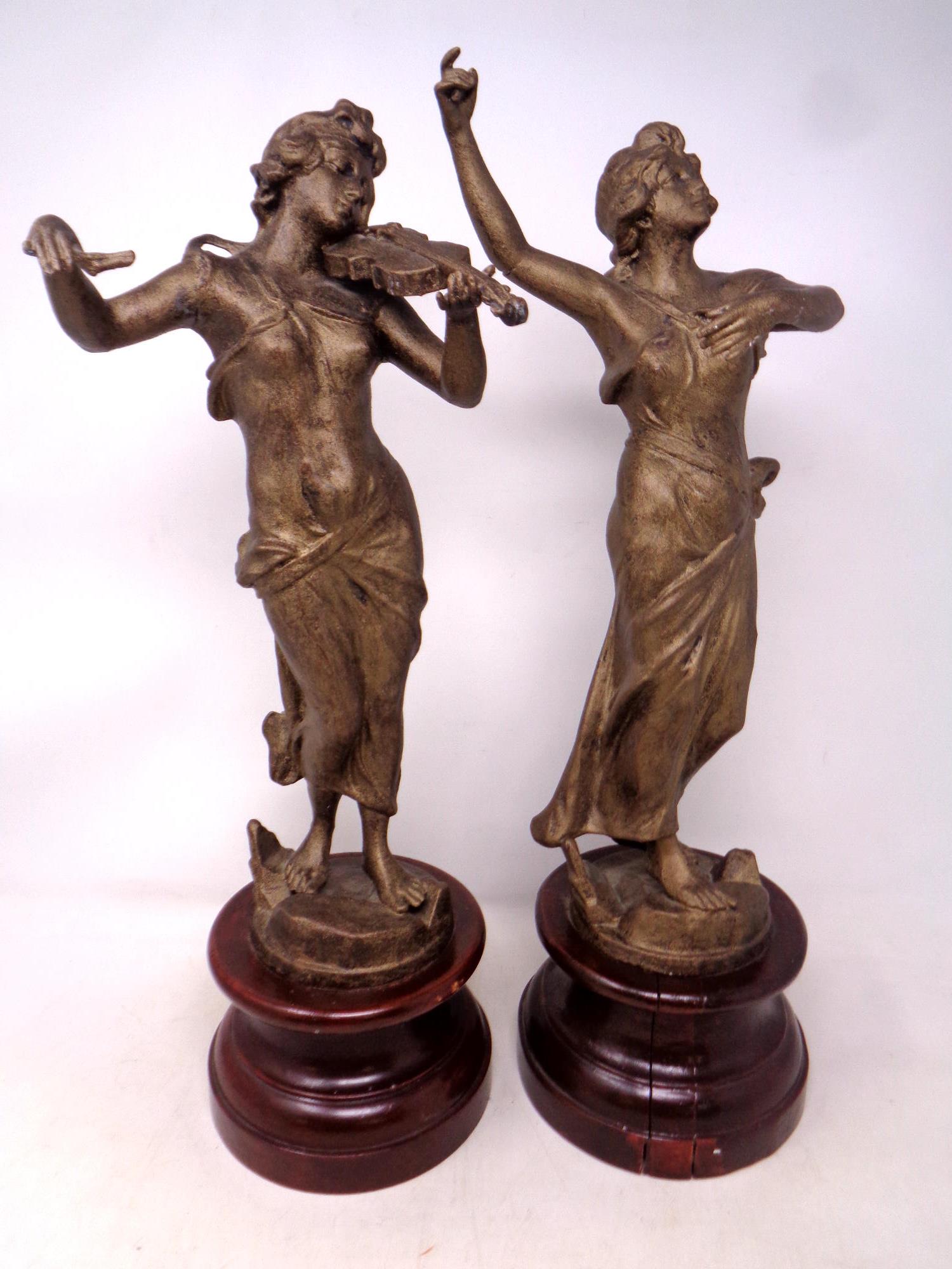 A pair of spelter figures on wooden plinths depicting musician and dancer