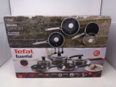 A Tefal Essential pan set together with a further Next aluminium pan set