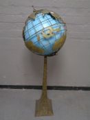 A gilt metal globe on pedestal