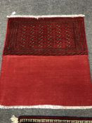 An eastern fringed cushion cover on red ground,