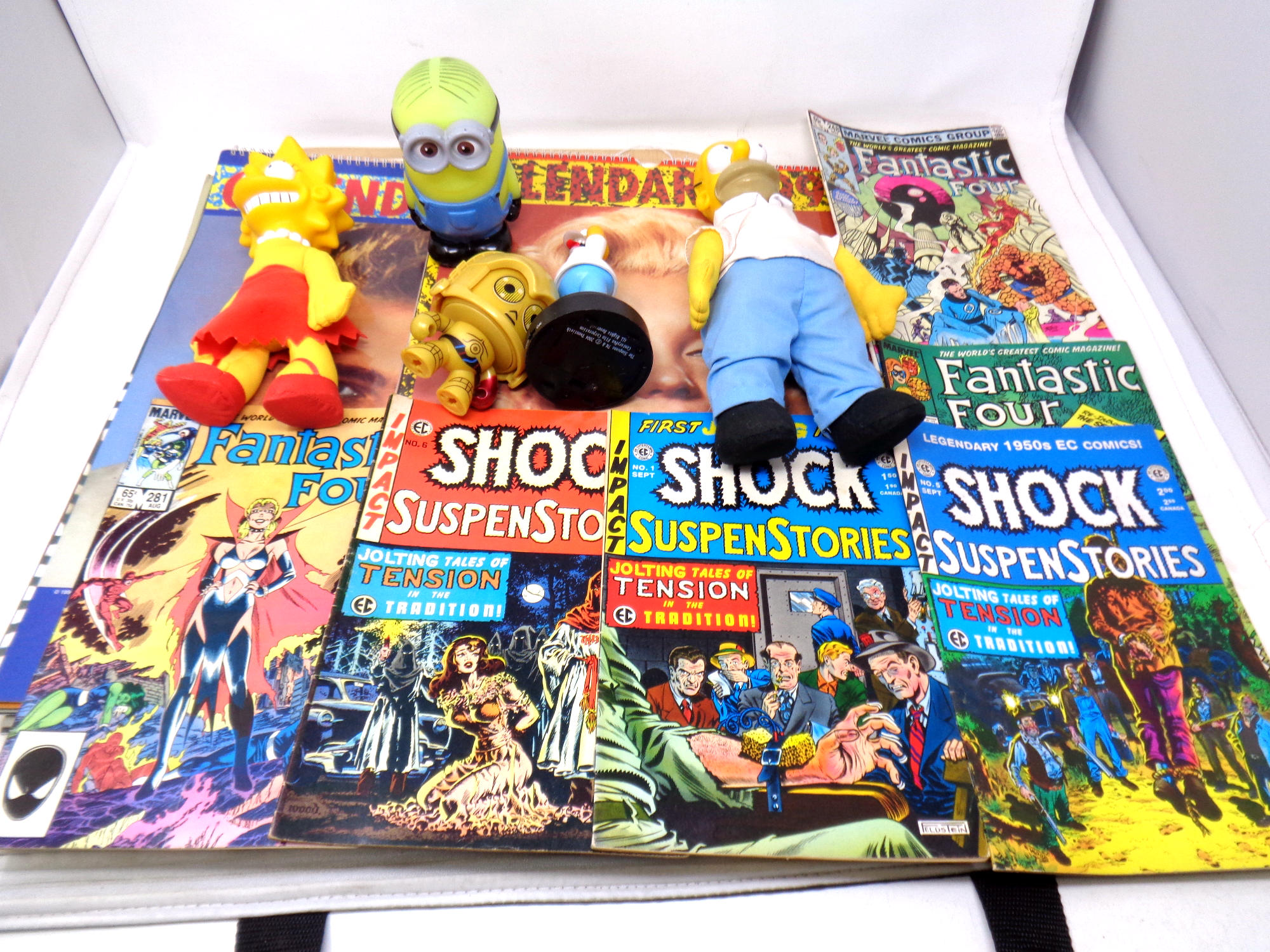 A collection of comics, Simpsons 1991 toys and others, James Dean and Marilyn Monroe calendars,